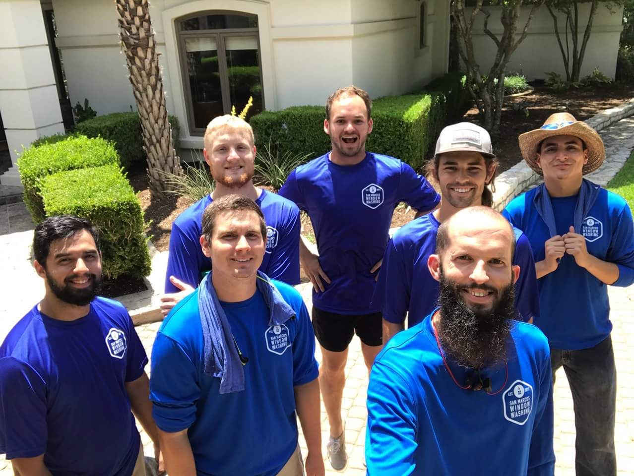 A group of men in blue shirts are posing for a picture