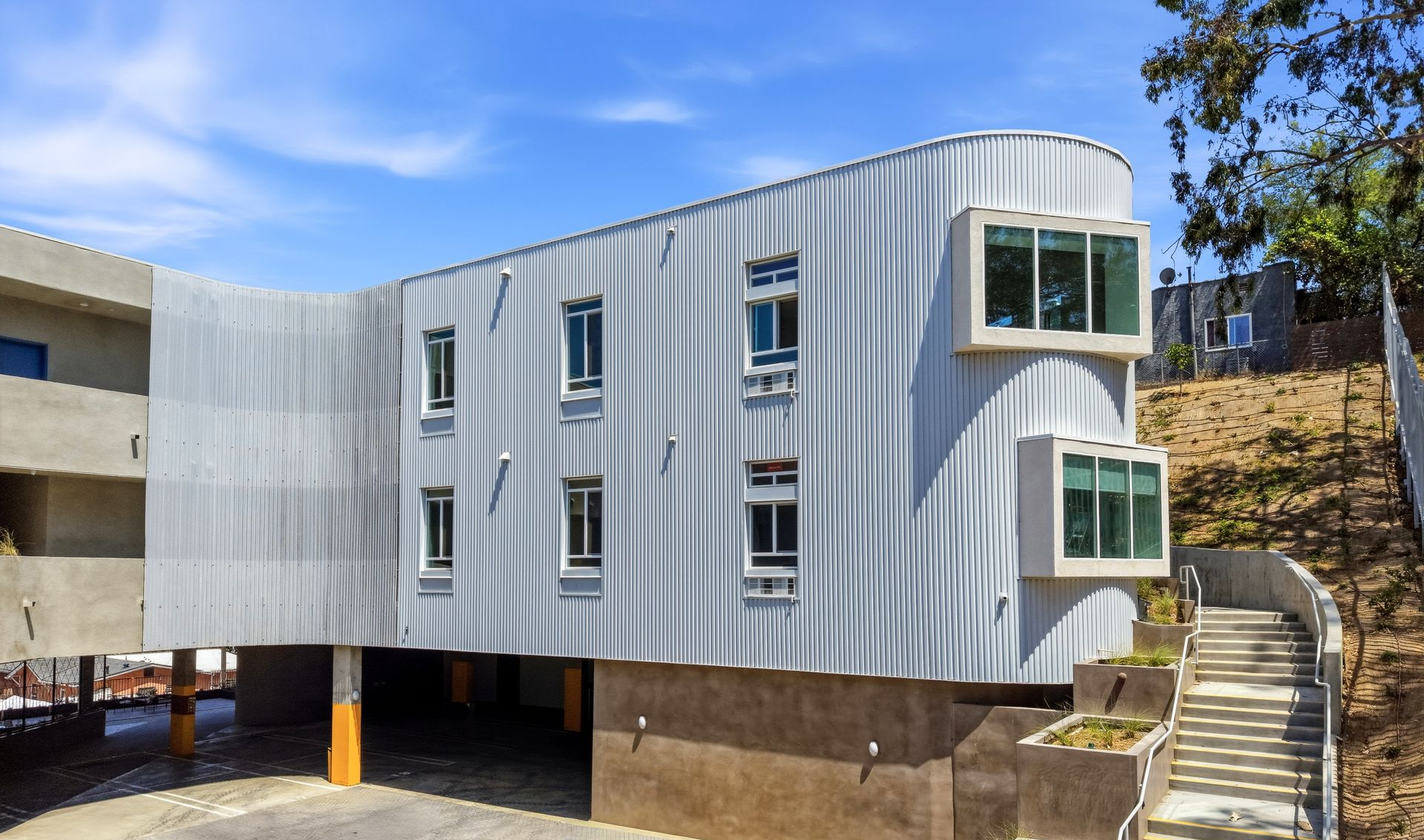 Apartment building with white metal siding and rectangular windows 