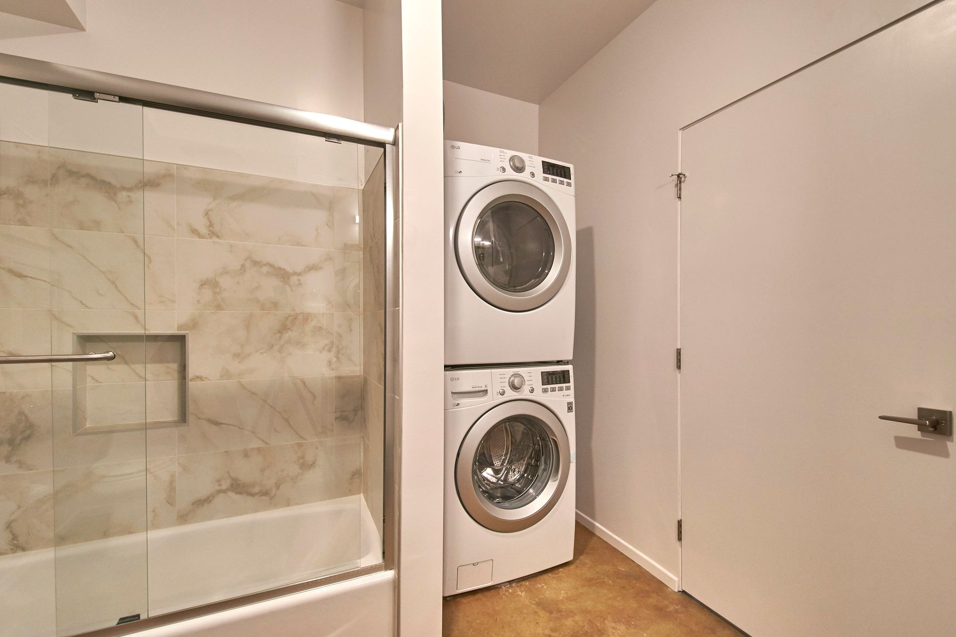 A bathroom with a washer and dryer stacked on top of each other.