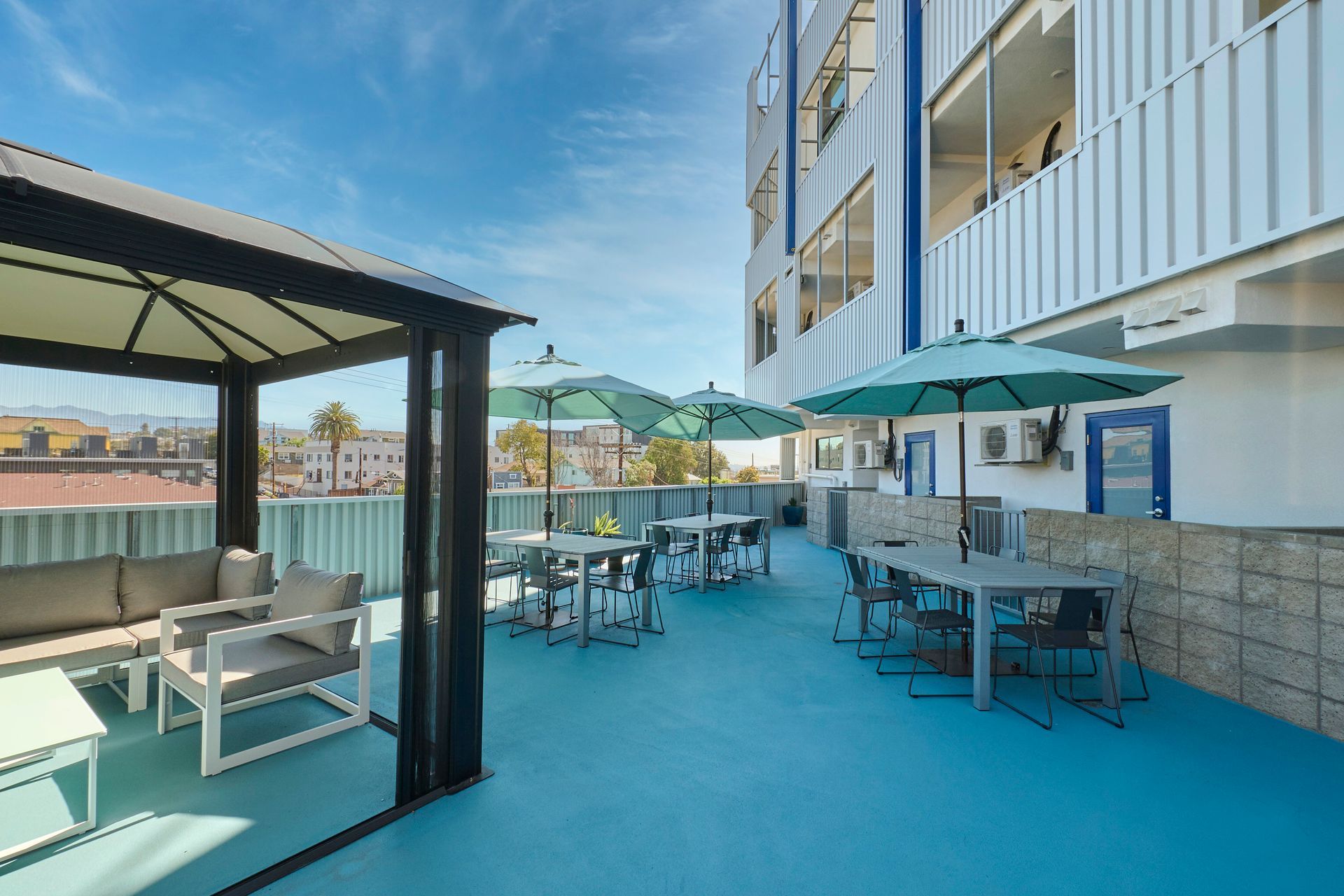 A patio with tables and chairs and umbrellas in front of a building