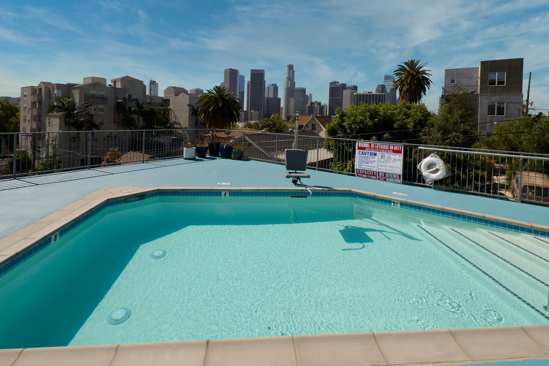 A large swimming pool with a city skyline in the background