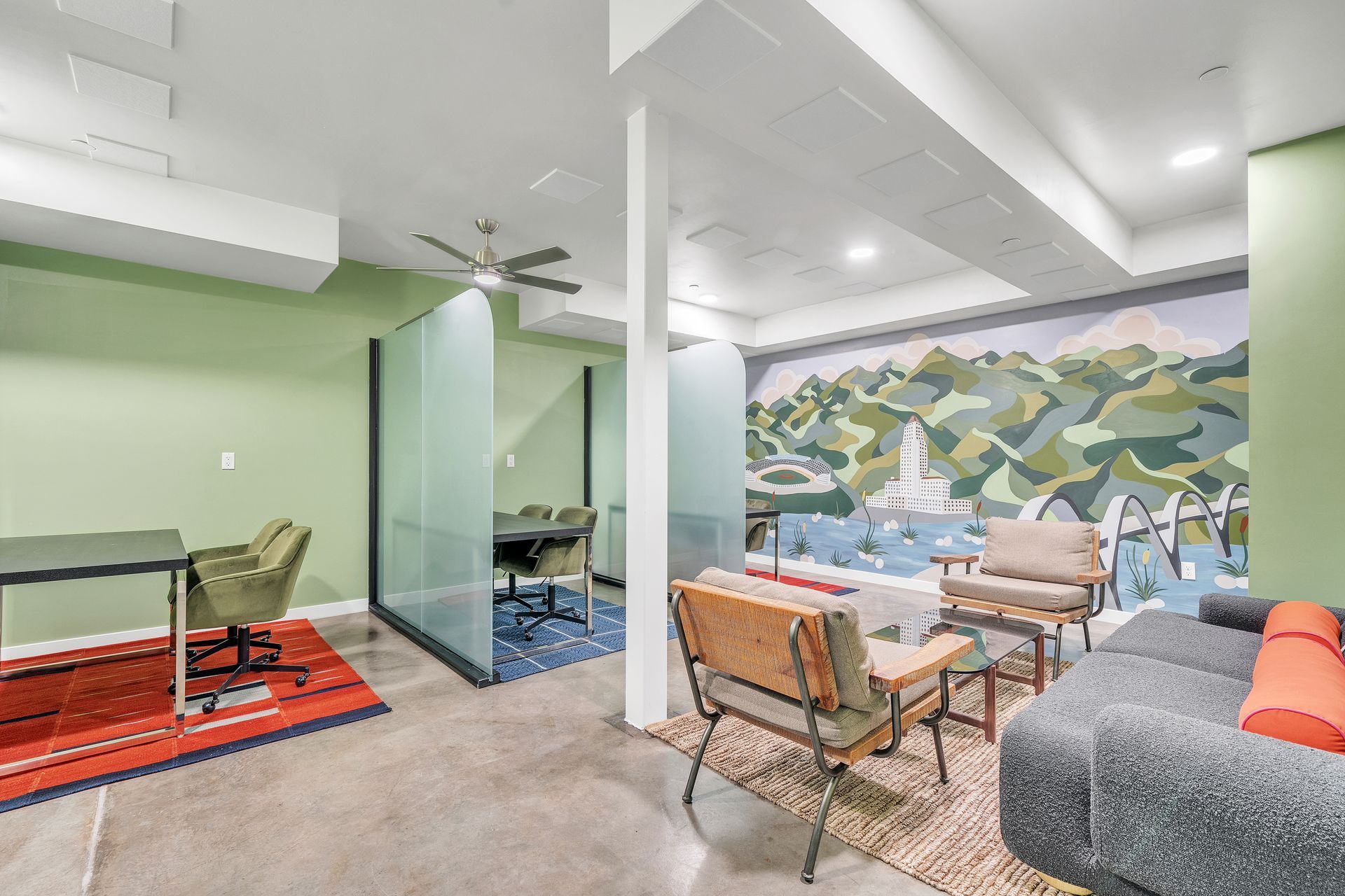 A living room with a couch , table , chairs and a painting on the wall.
