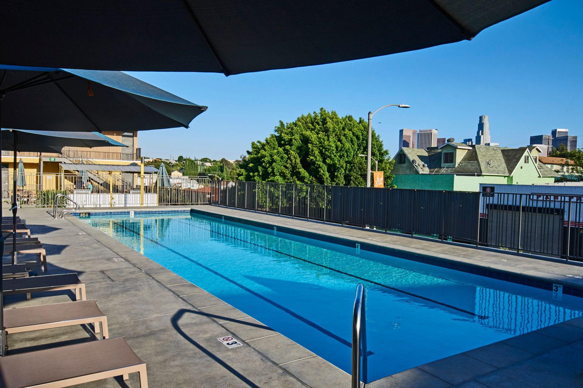 A large swimming pool surrounded by chairs and umbrellas
