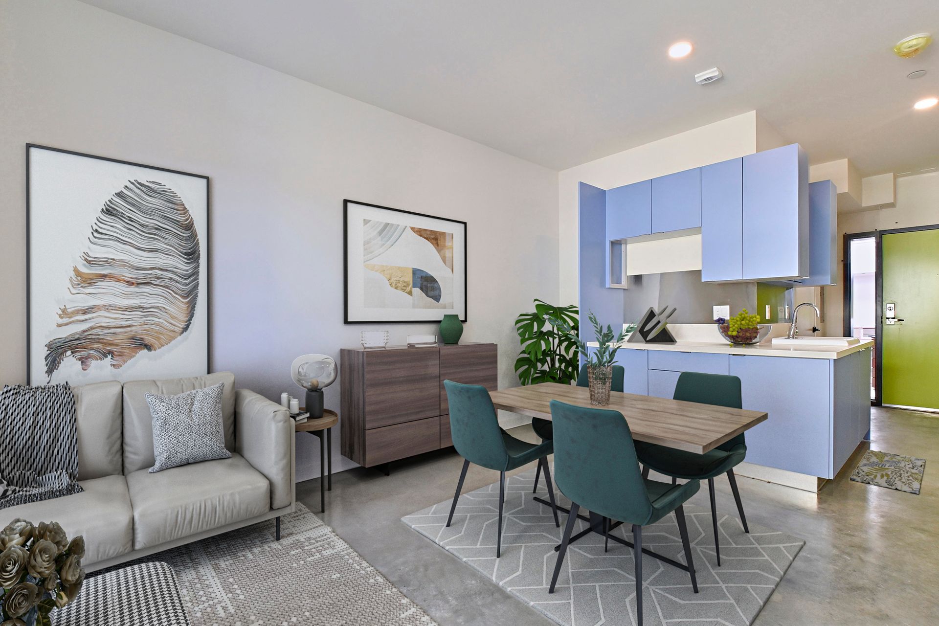 Modern living-dining area with gray sofa, teal chairs, wood table, and blue kitchen cabinets