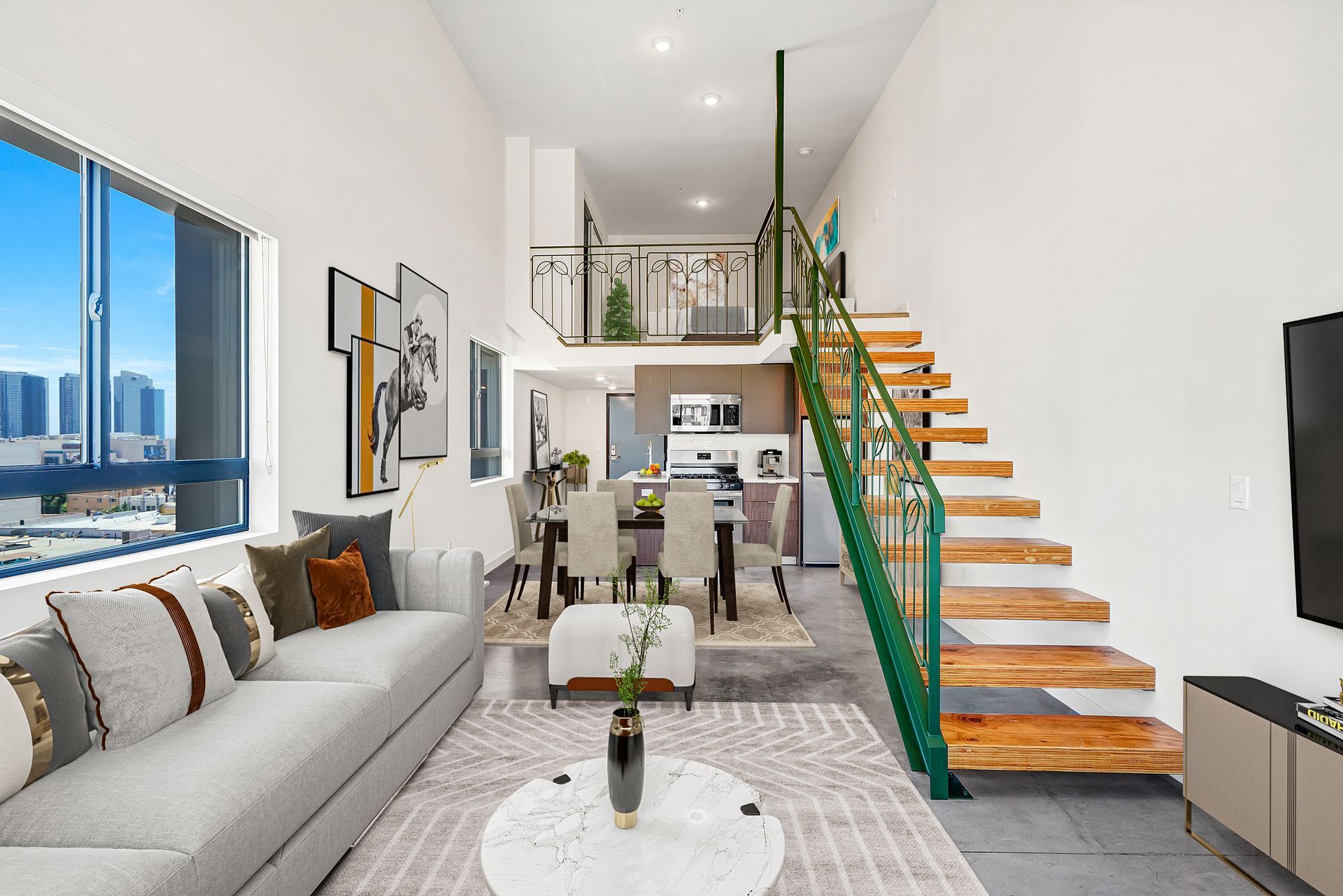 Modern loft living space with high ceilings, stairs, and a dining area.