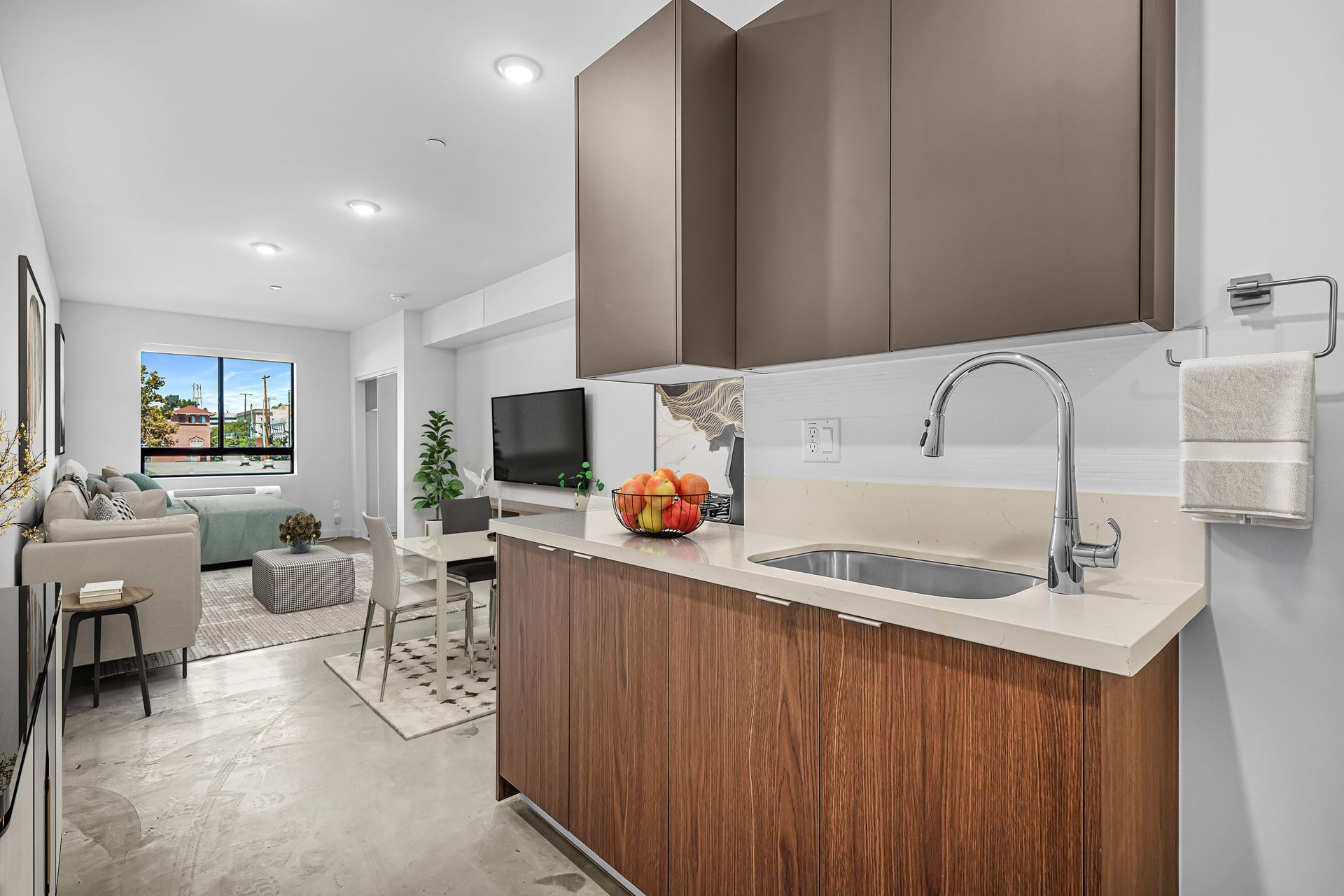 A kitchen with wooden cabinets and a sink in a living room.