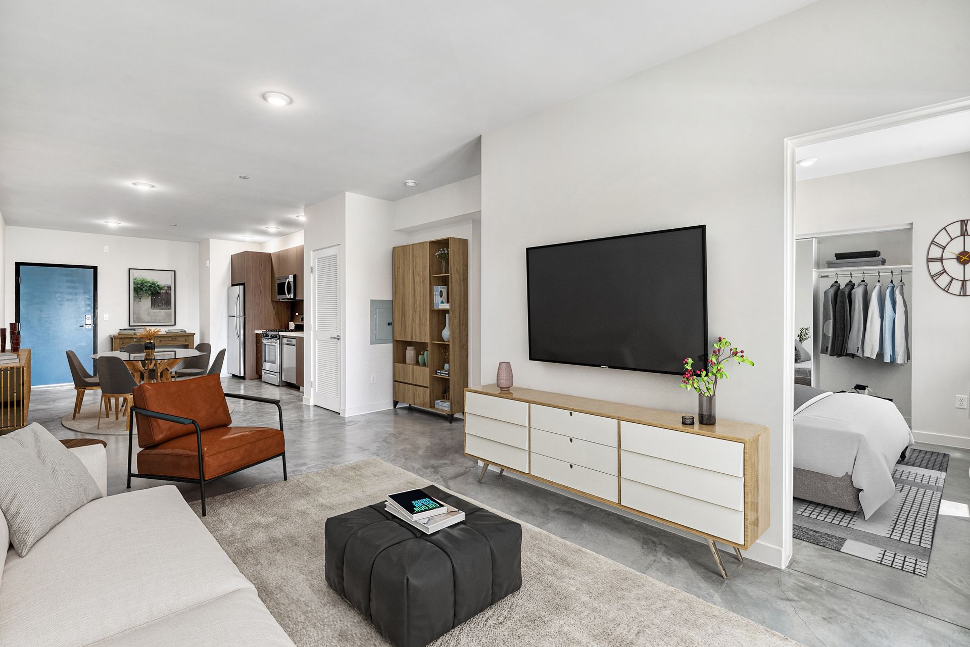 A living room with a couch , chair , coffee table and television.