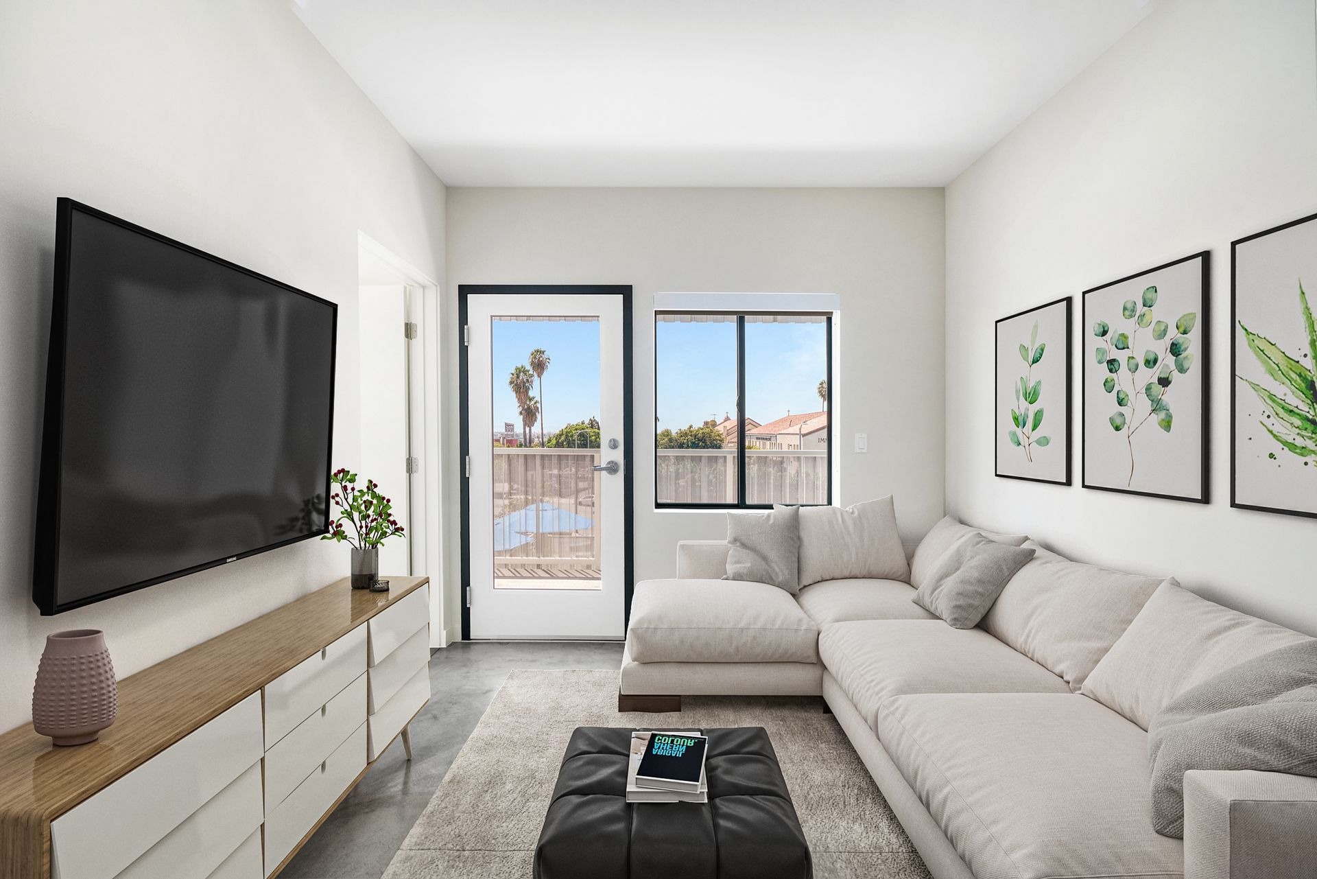 A living room with a large sectional couch and a flat screen tv.