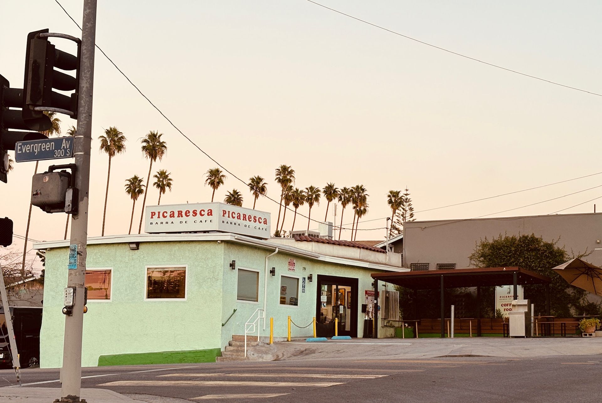 A pale green building with a sign that reads 