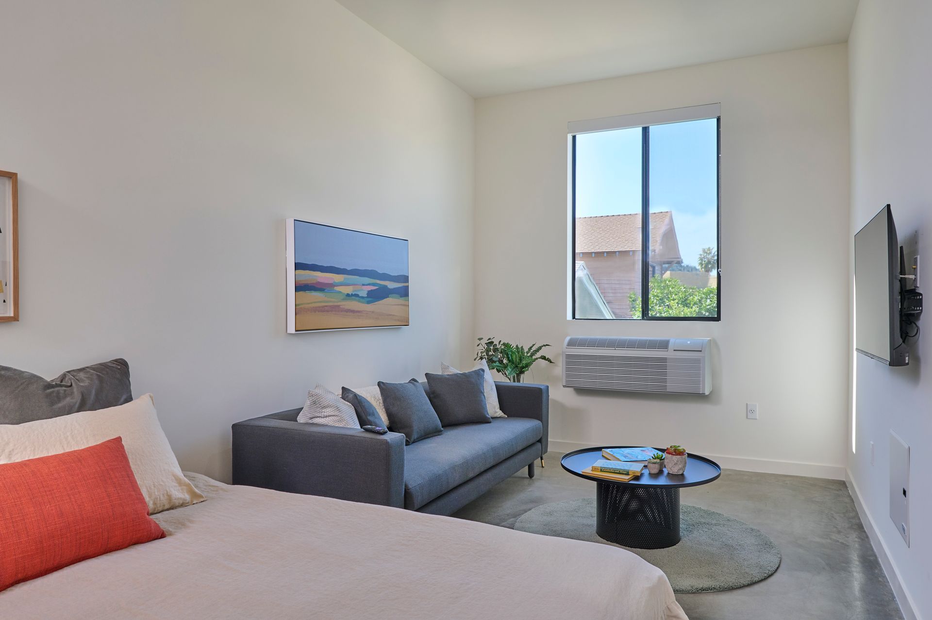 A bedroom with a bed , couch , coffee table and television.
