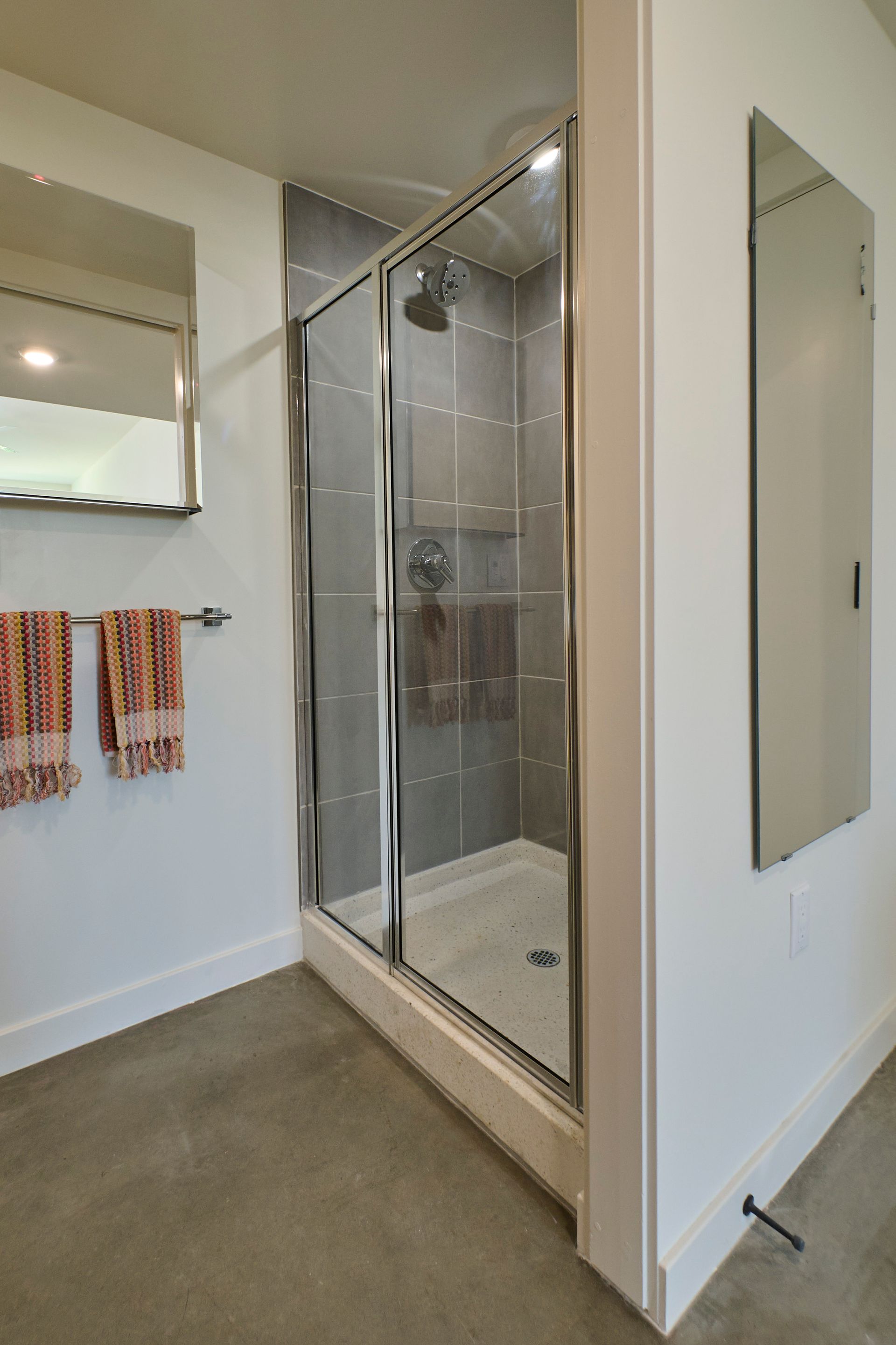 A bathroom with a walk in shower and a mirror