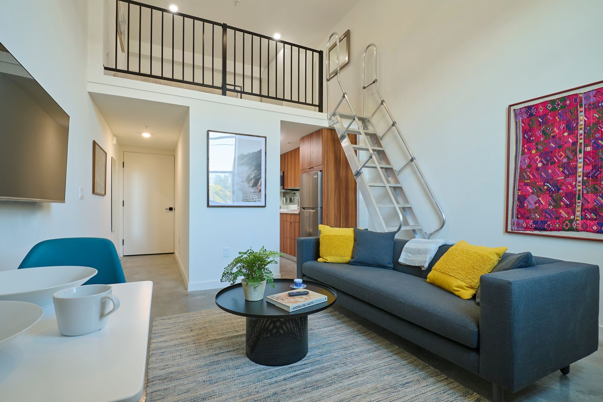 A living room with a couch , coffee table , and stairs leading to the second floor.