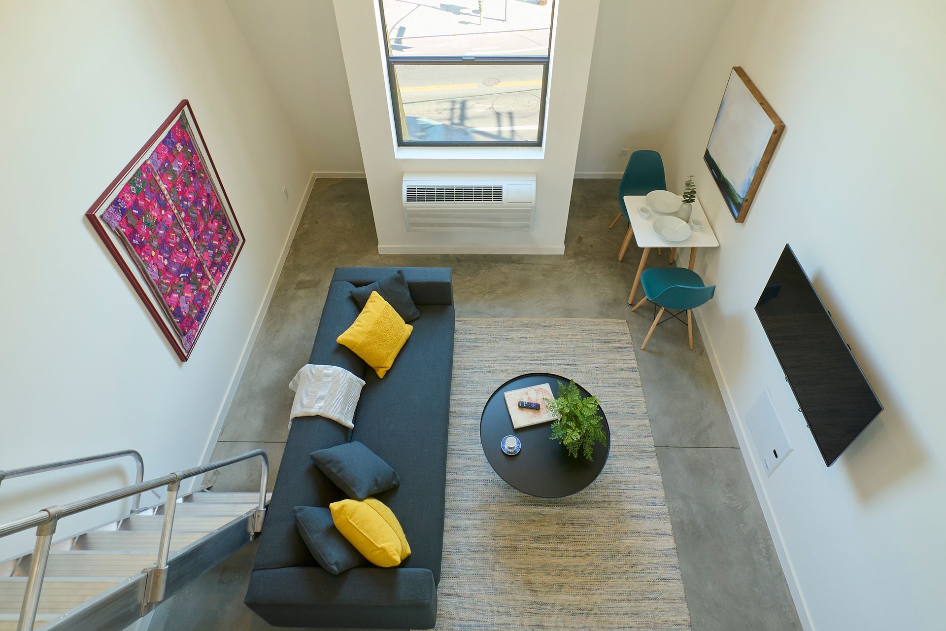 An aerial view of a living room with a couch , table and television.