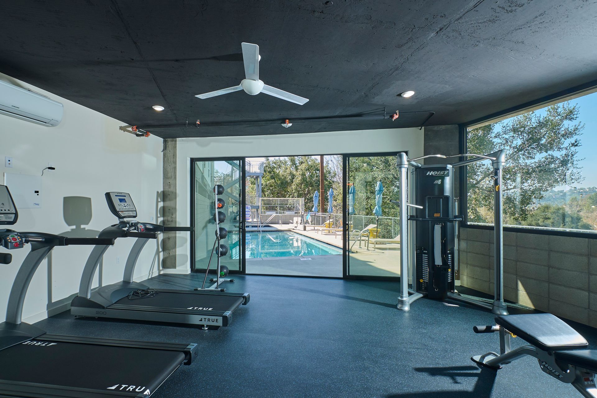 A gym with treadmills and a ceiling fan.