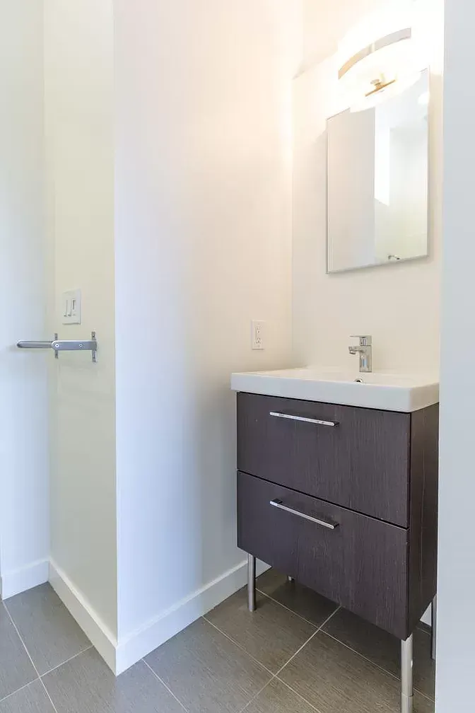 A bathroom with a sink , mirror and shower.
