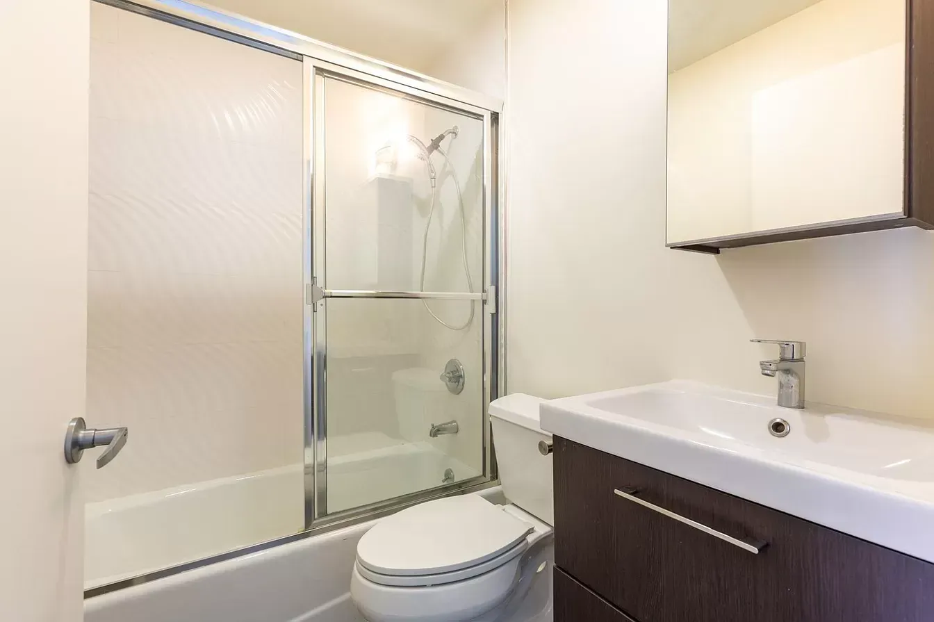 A bathroom with a toilet , sink , bathtub and shower.