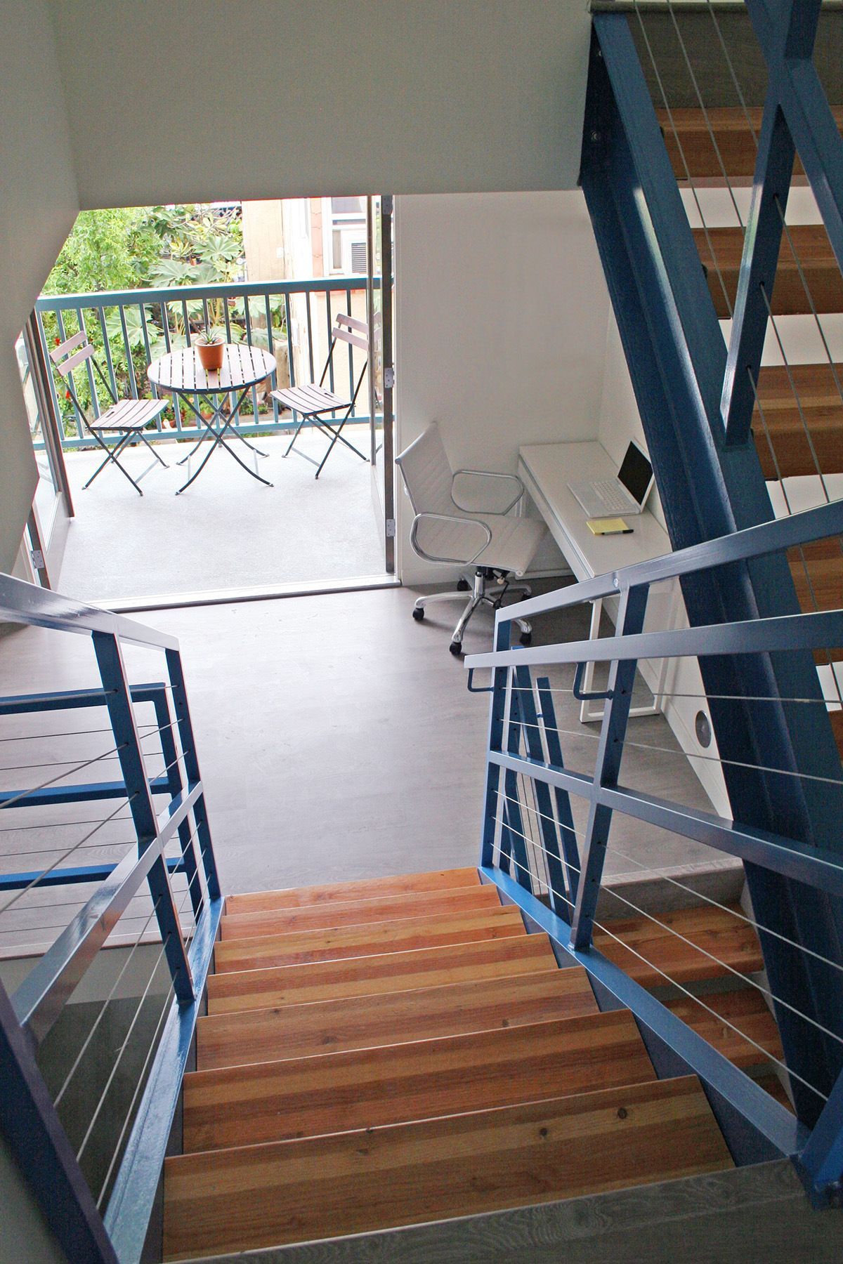 Stairs leading up to a balcony with a table and chairs