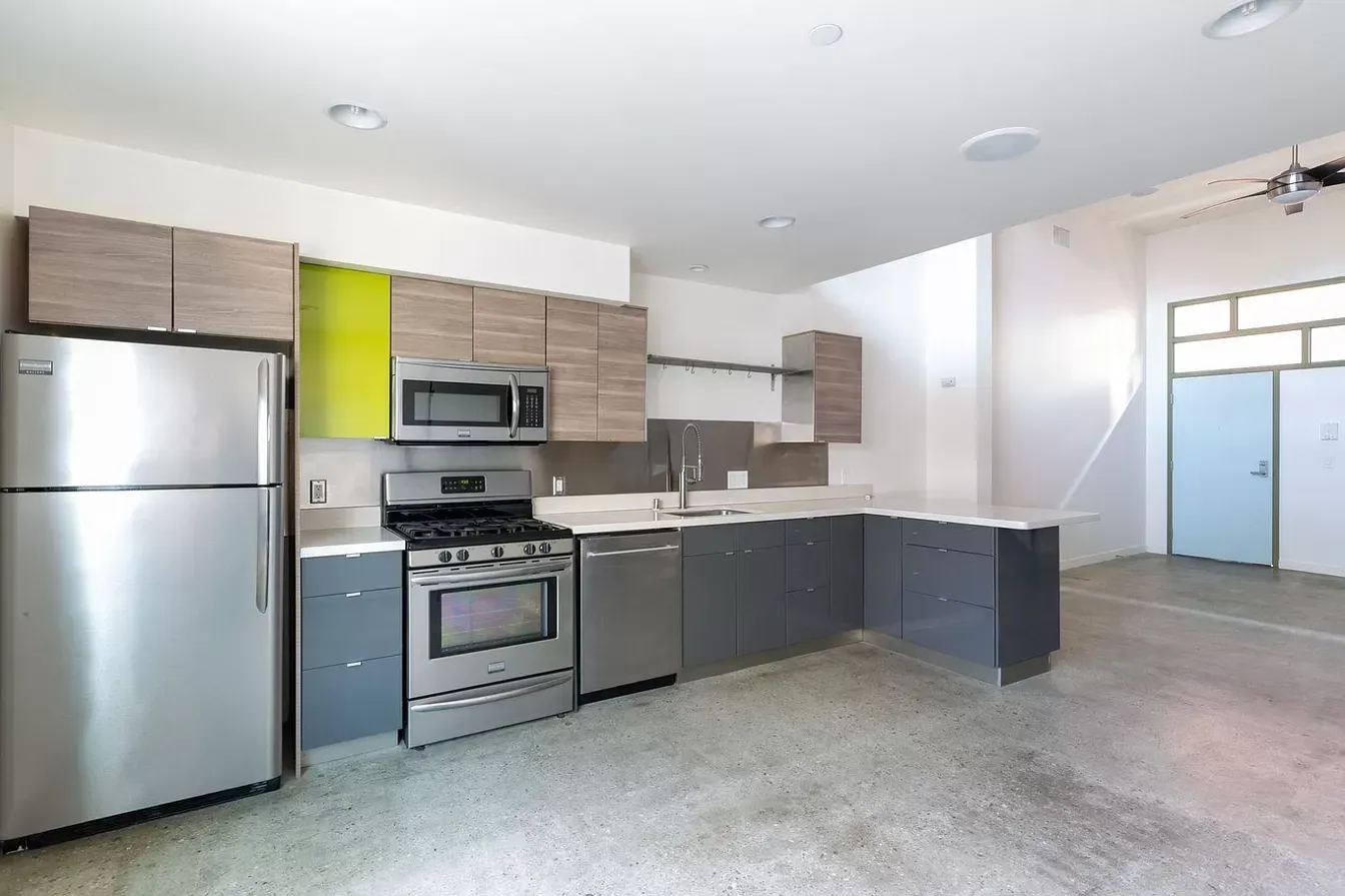 A kitchen with stainless steel appliances and a refrigerator