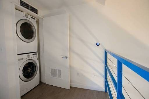 A laundry room with a washer and dryer stacked on top of each other.