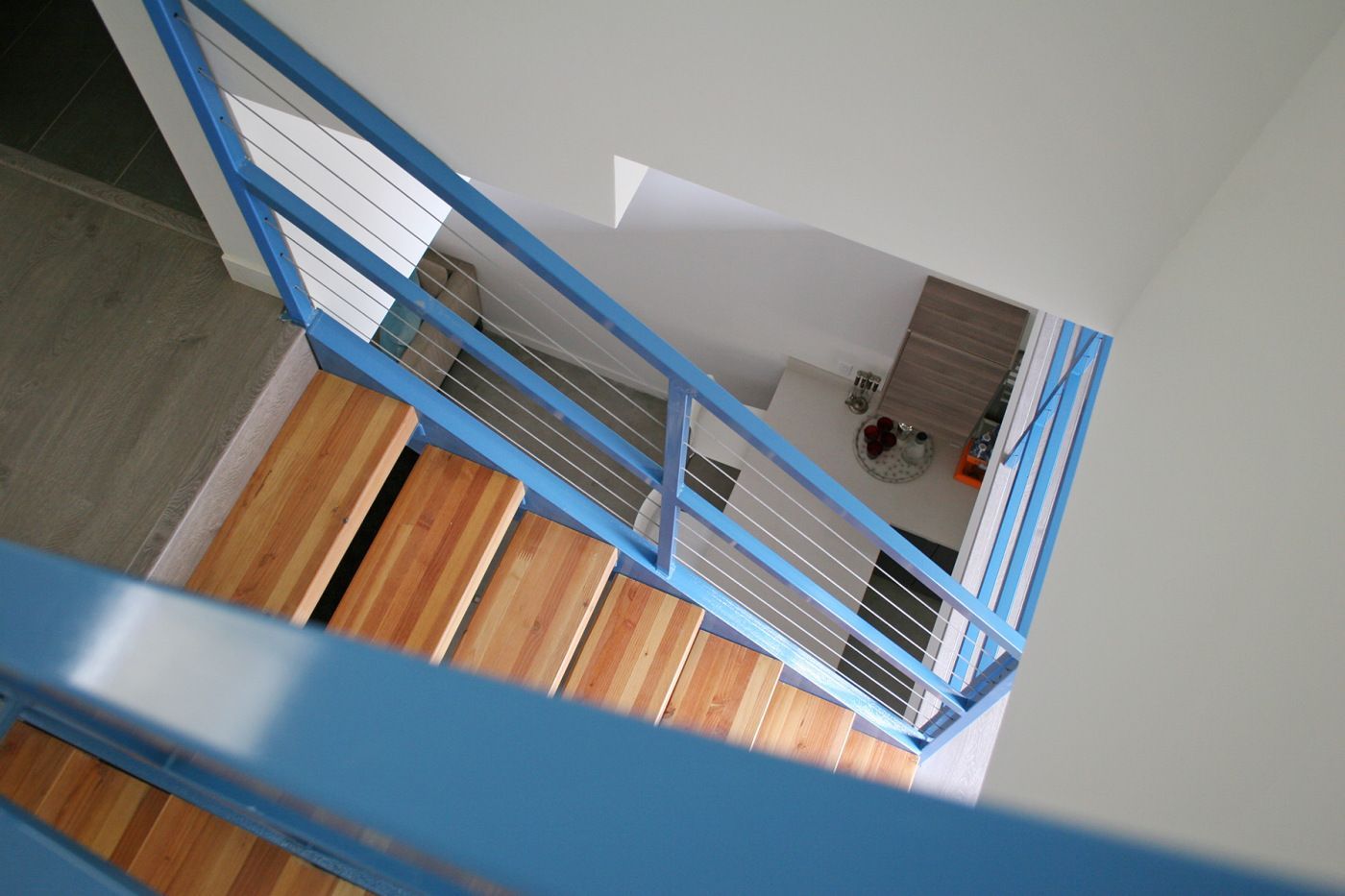 A staircase with a blue railing and wooden steps