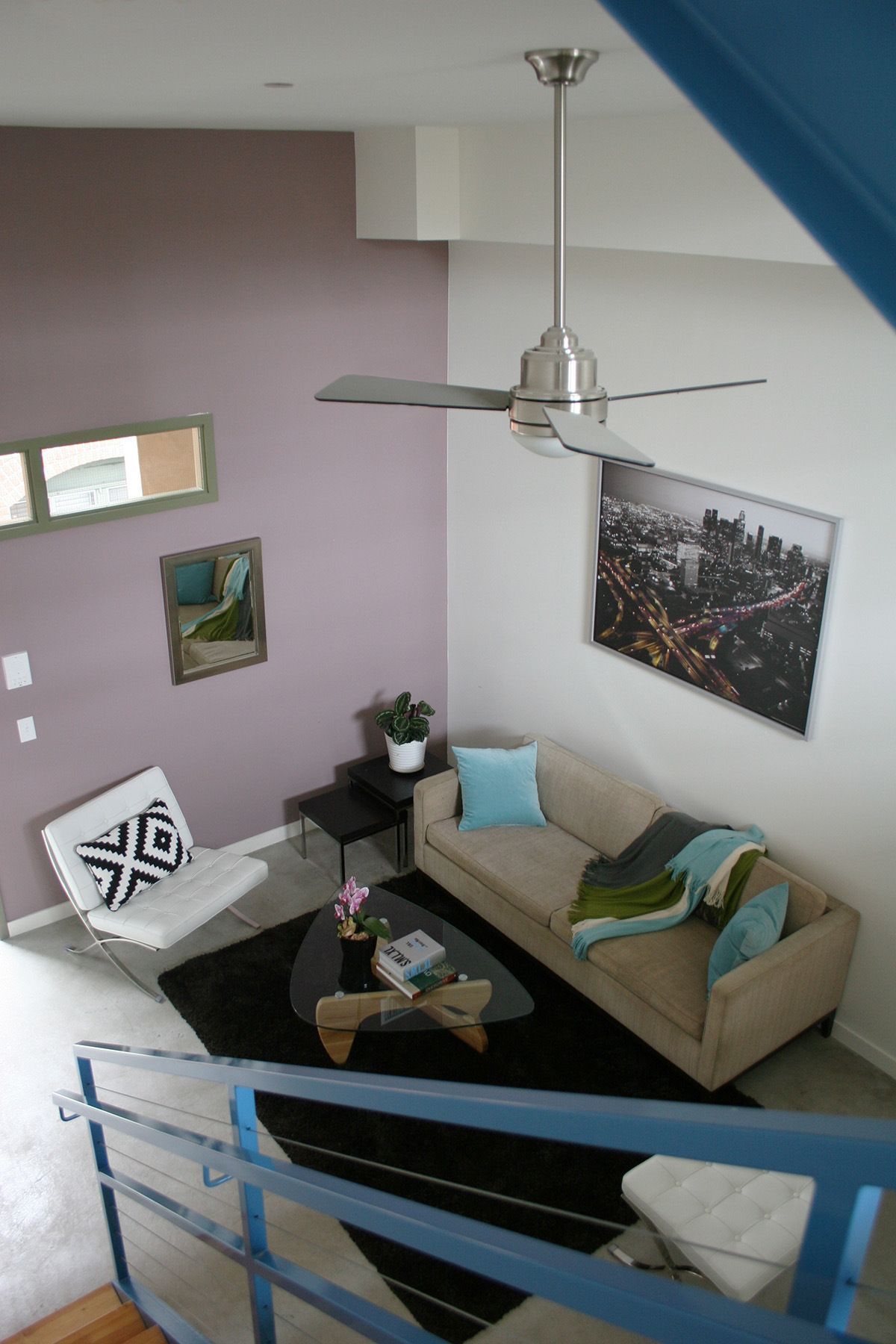 A living room with a couch a chair and a ceiling fan