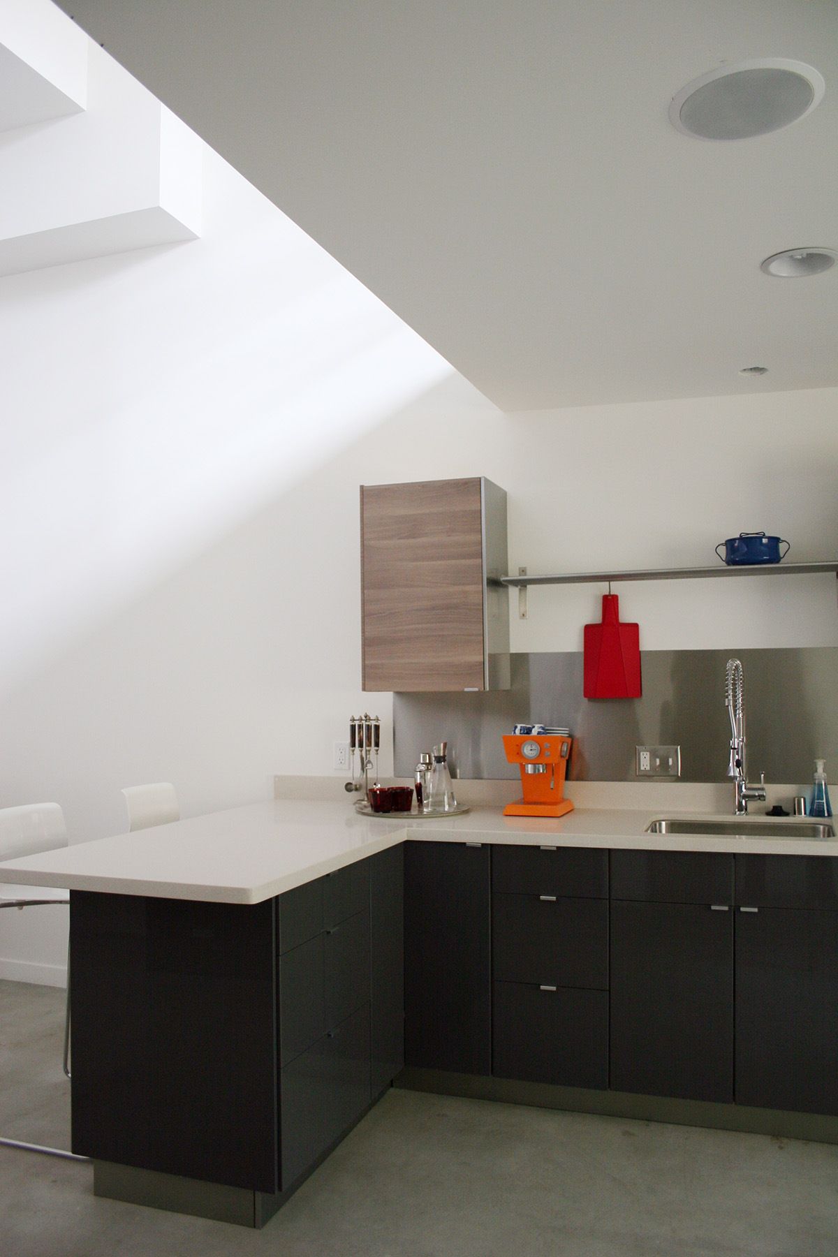 A kitchen with black cabinets and white counter tops