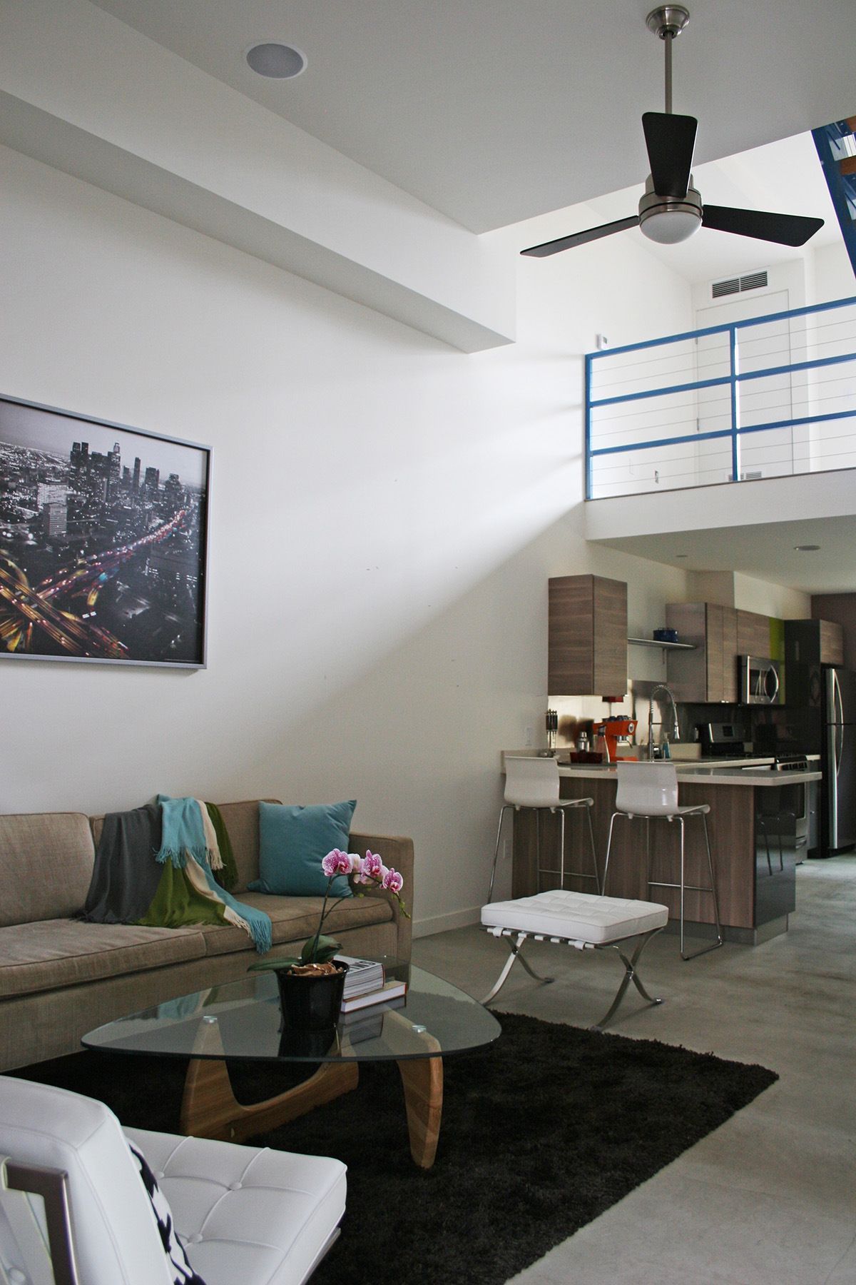 A living room with a ceiling fan and a picture on the wall