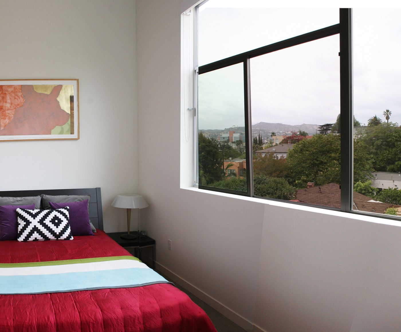 A bedroom with a bed and a large window