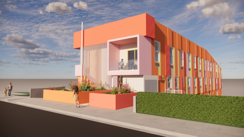 Colorful, modern building with orange, pink, and yellow hues; people on sidewalk, and a small green hedge.