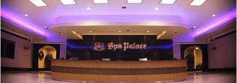 Reception area of Spa Palace with purple lighting and a brown front desk.