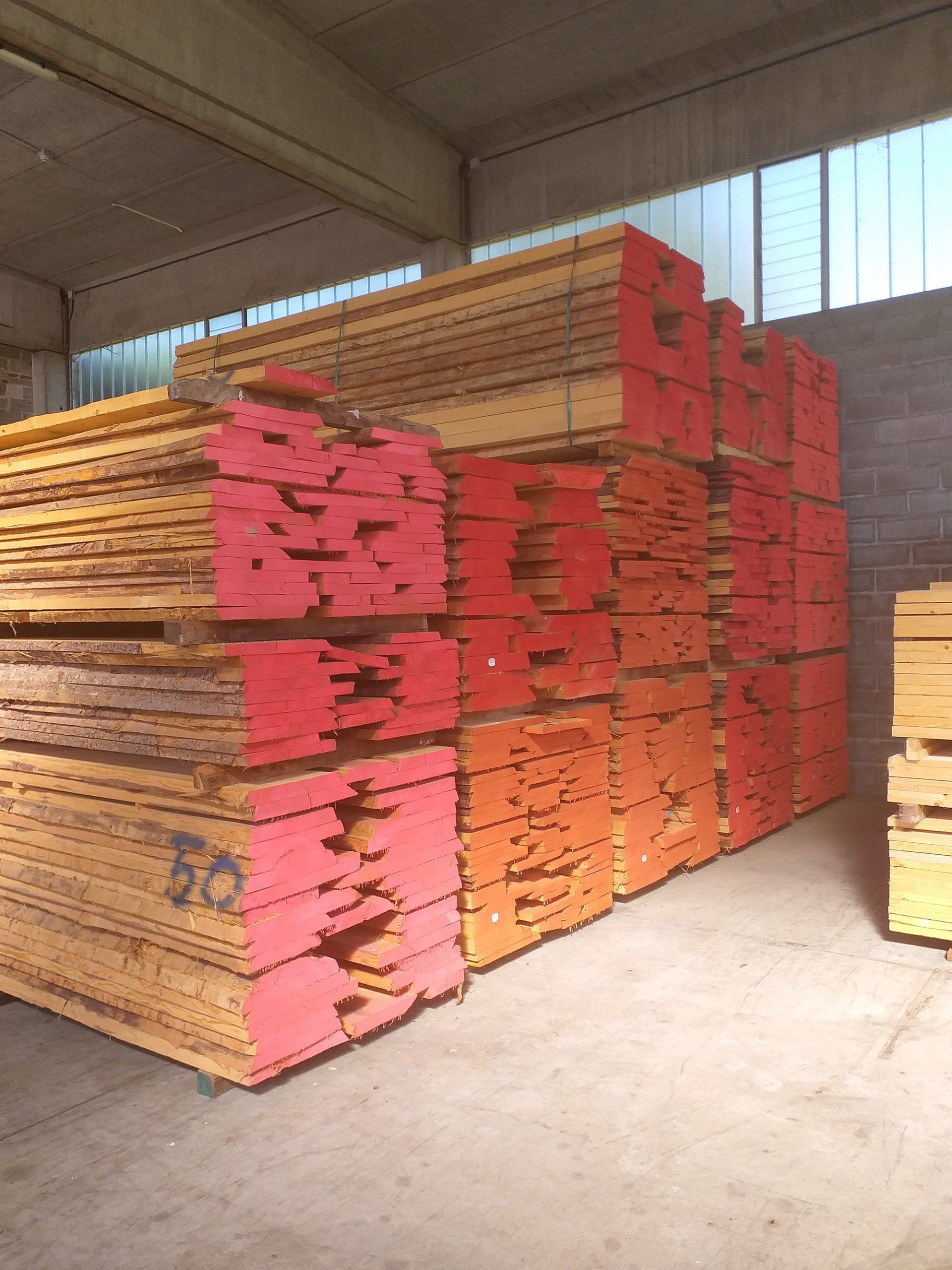 Pile di assi di legno all'interno di un magazzino.