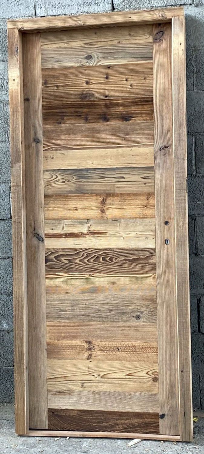 Una porta rustica in legno realizzata con assi di legno di recupero.