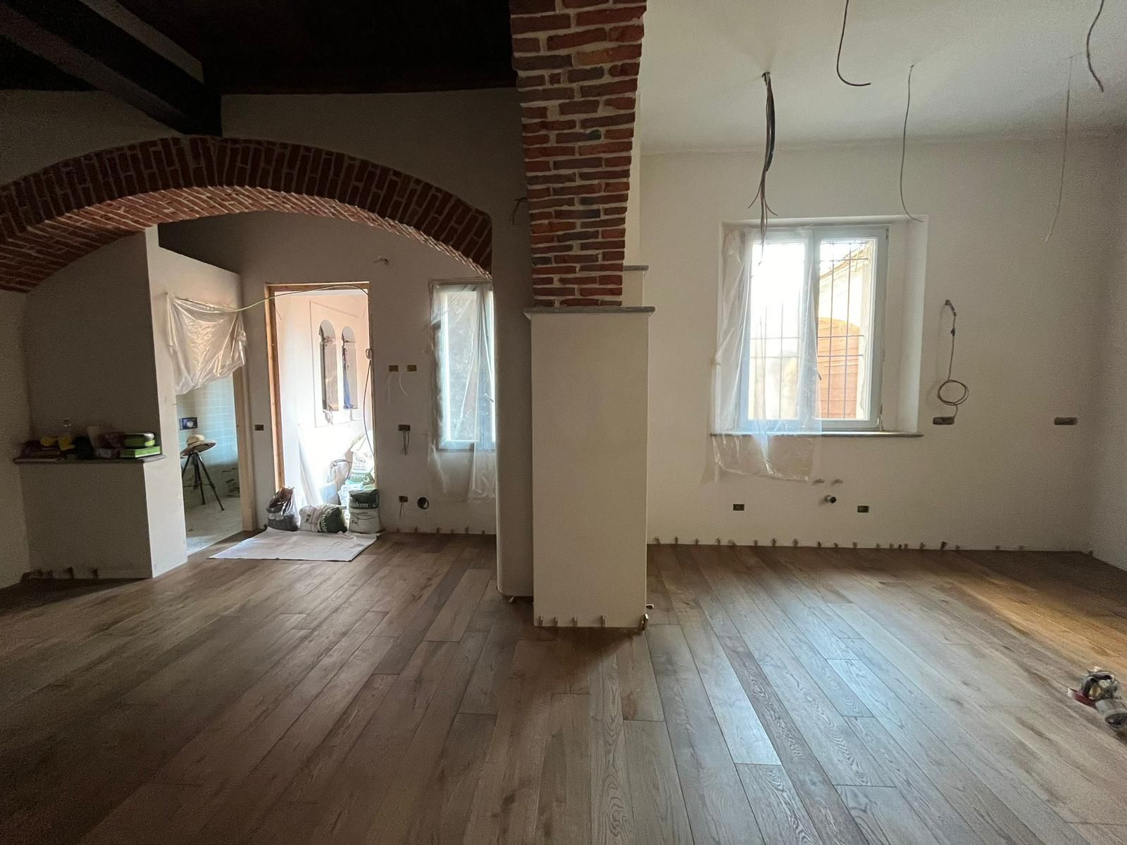 Interno di una stanza in fase di ristrutturazione con pavimenti in legno.