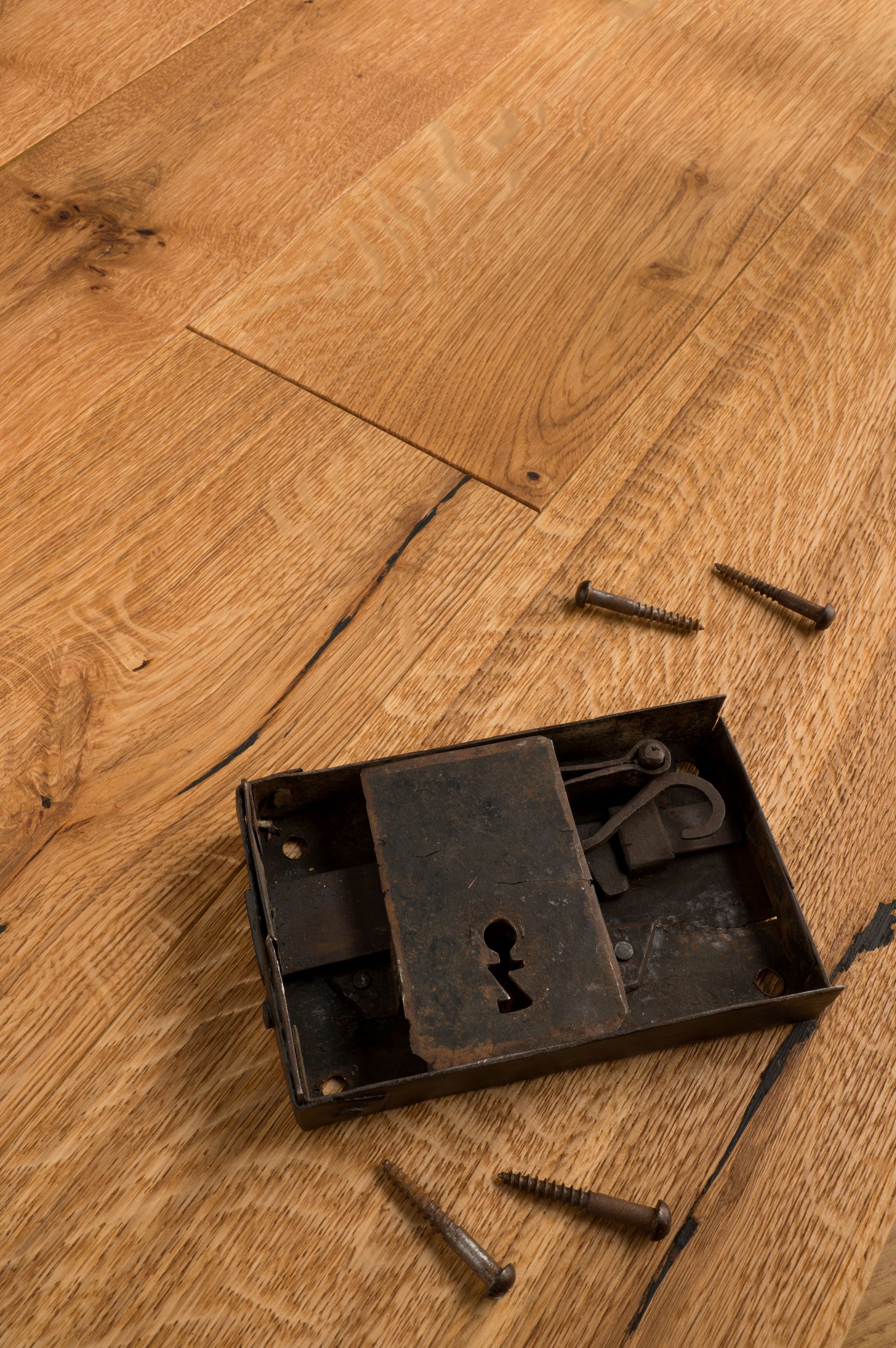 Una superficie di legno marrone chiaro, con venature e crepe visibili.