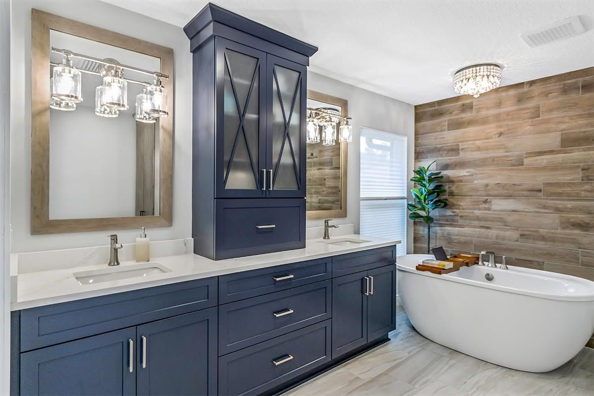 Modern bathroom with navy double vanity, wood accent wall, and freestanding tub