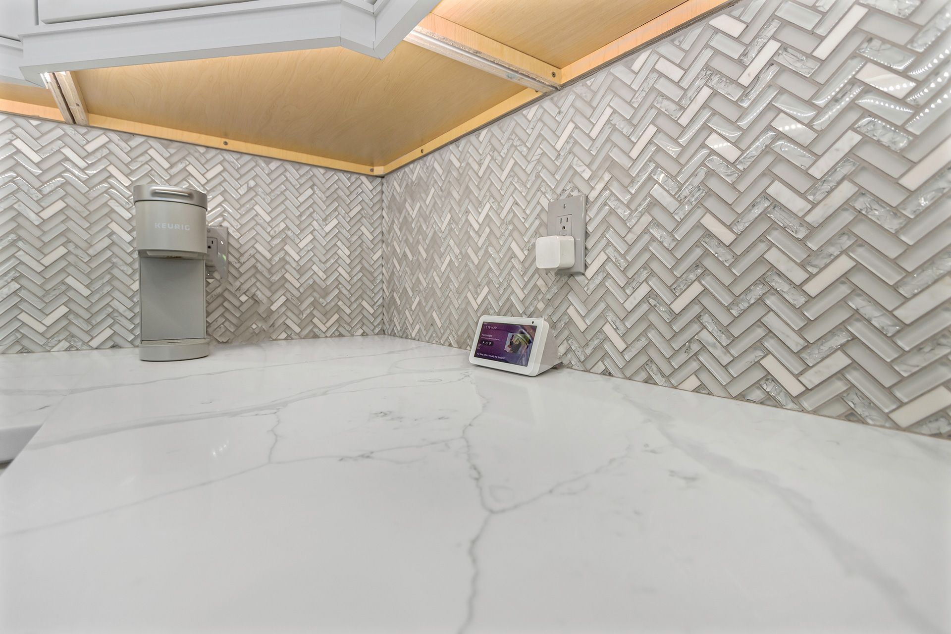 Bedroom corner with tufted gray headboard, cream dresser, floral wallpaper, and mauve lamp