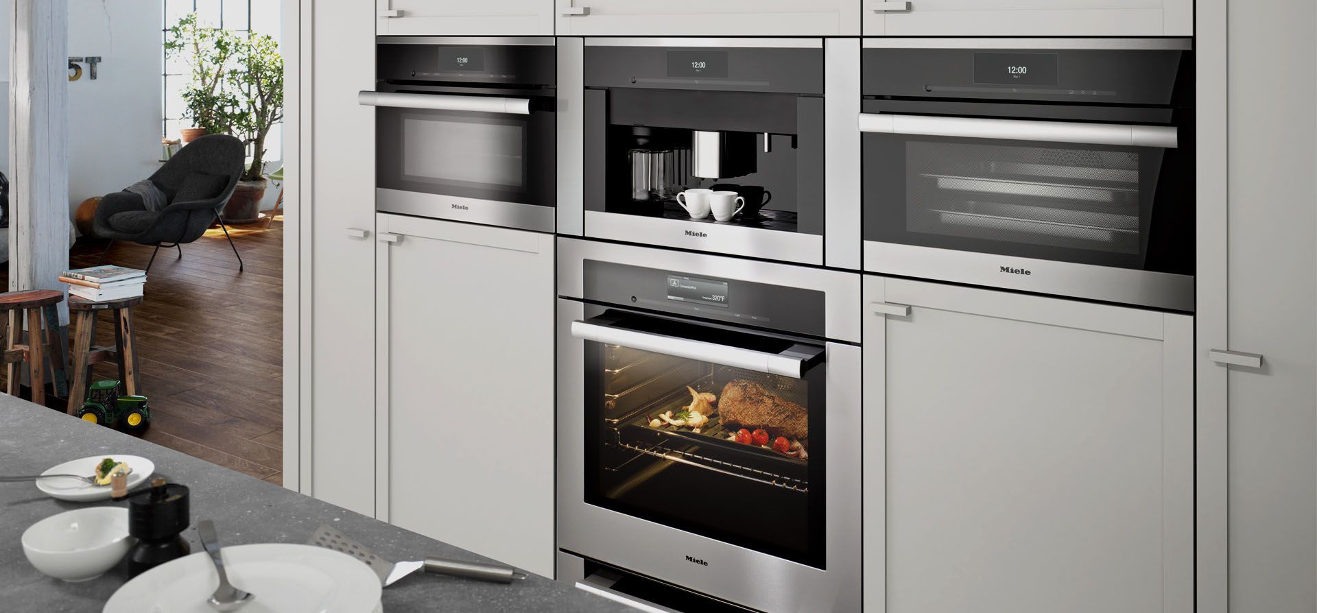 Modern built-in kitchen with stainless steel oven, microwave, and cabinetry next to a dining area