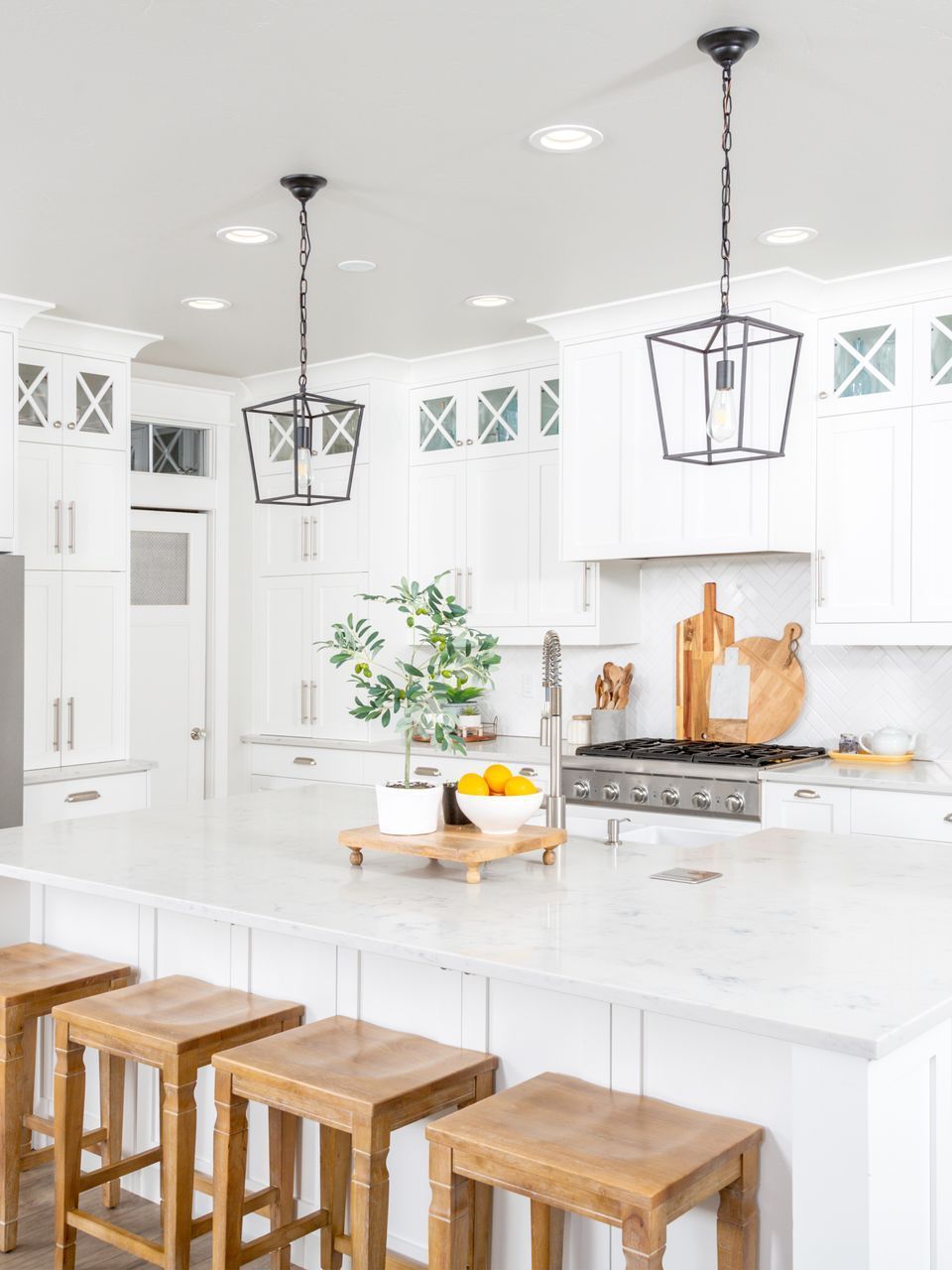 A kitchen with white cabinets and wooden stools