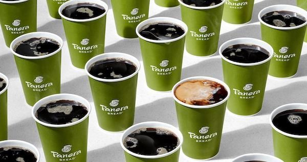 A bunch of green panera cups filled with coffee
