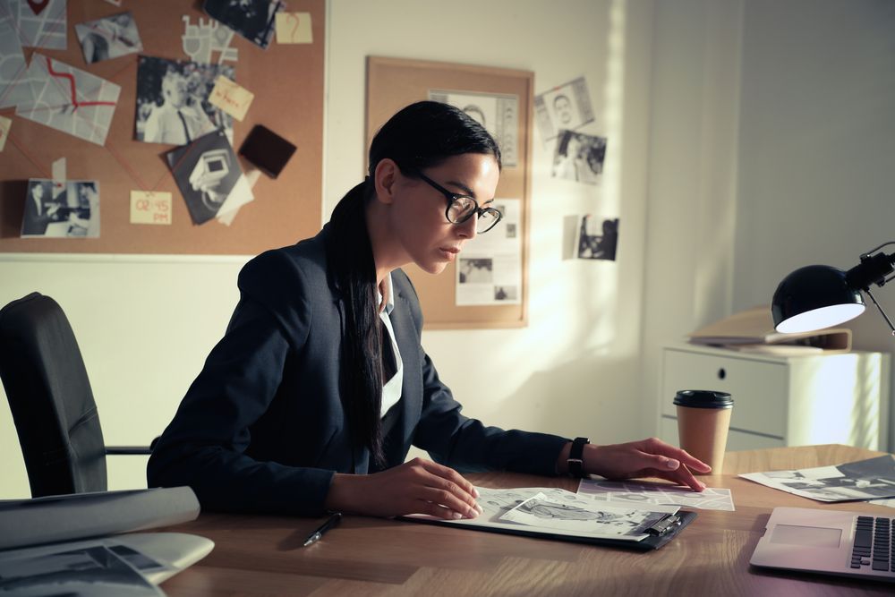 a woman is sitting at a desk with a laptop and a cup of coffee .