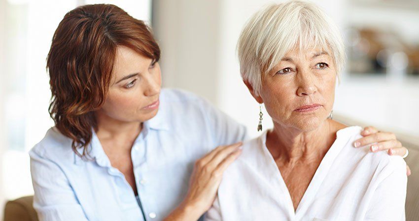 Younger woman holding older womans shoulders