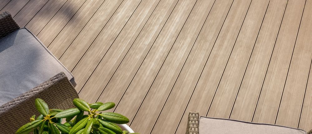 Wooden deck with two lounge chairs and a potted plant in the corner