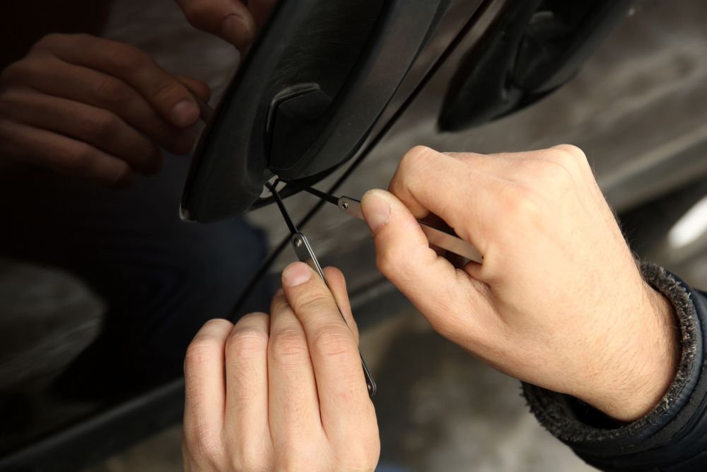 Hands Picking a Car Door Lock With Lock-picking Tools, Attempting to Unlock It — Lady Locksmith in Mackay, QLD