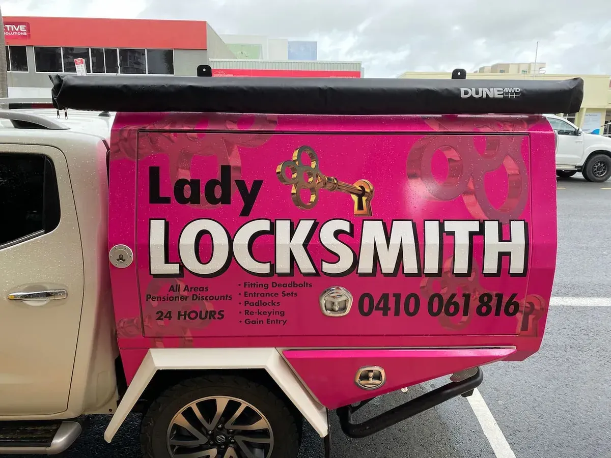 Pink Lady Locksmith Truck With Black Awning and White Text — Lady Locksmith in Mackay, QLD