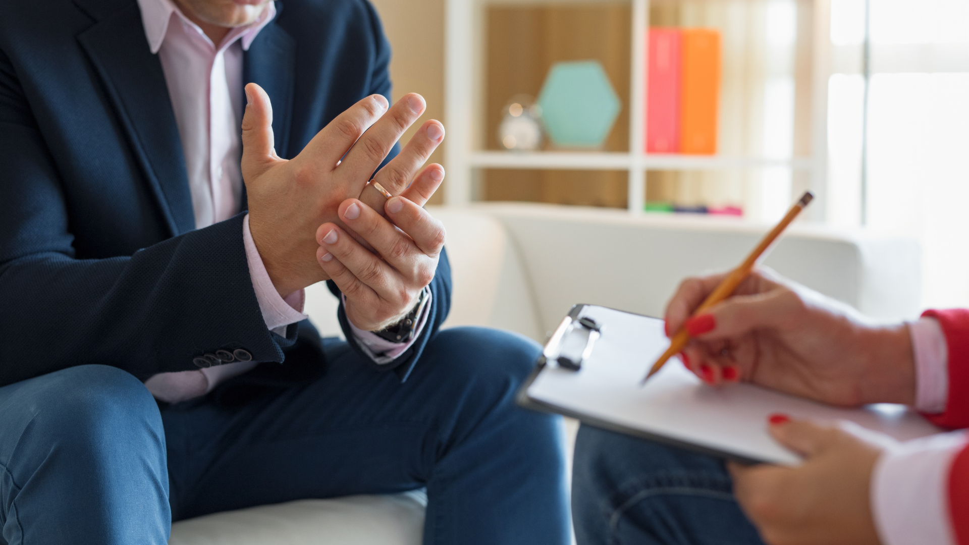 A woman is writing on a clipboard while talking to a man in a suit.