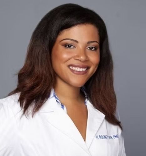 A woman wearing a white lab coat with the name h. rong on it