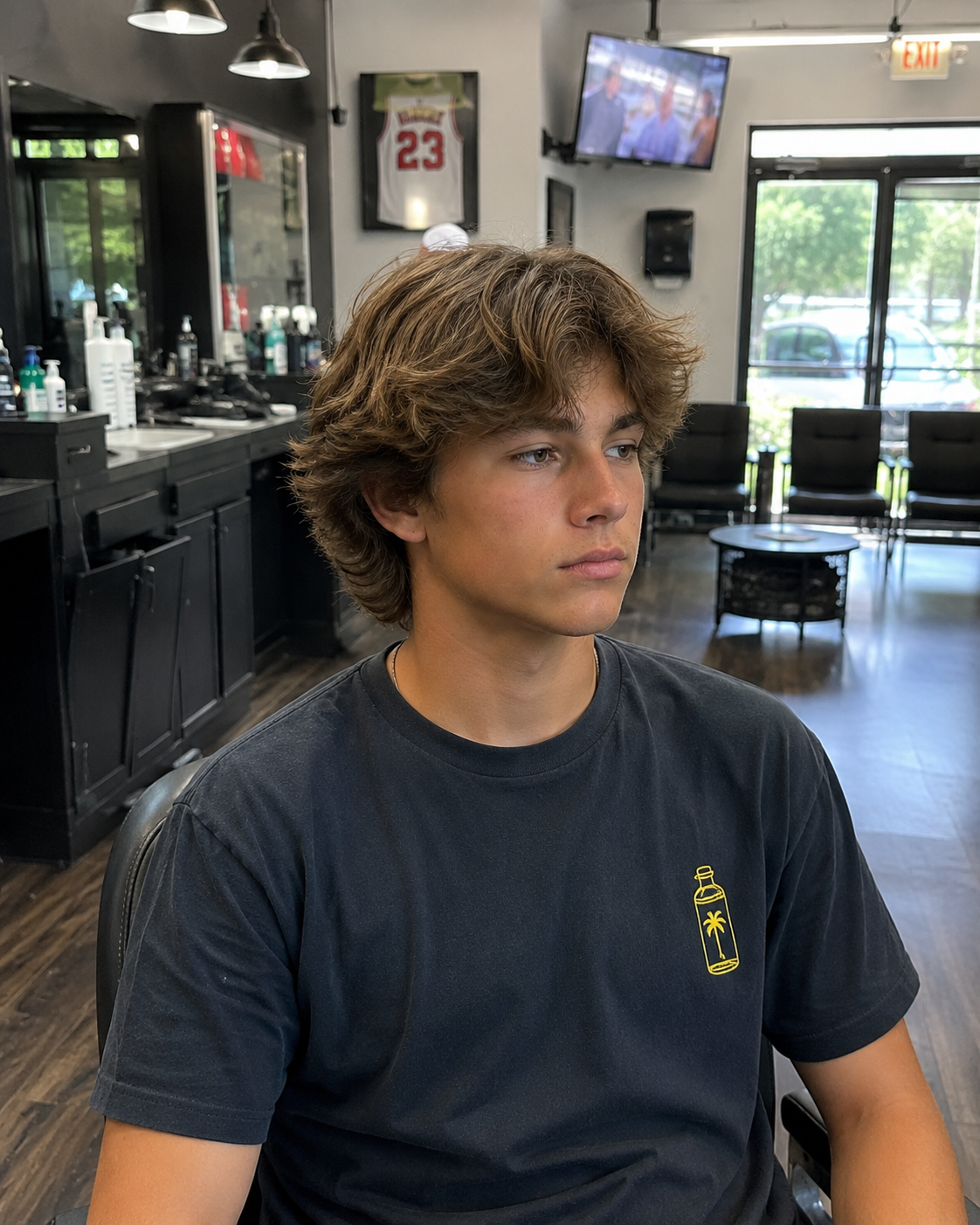 Teen client with a classic baseball flow haircut with a medium-length textured layers, creating a relaxed and athletic style