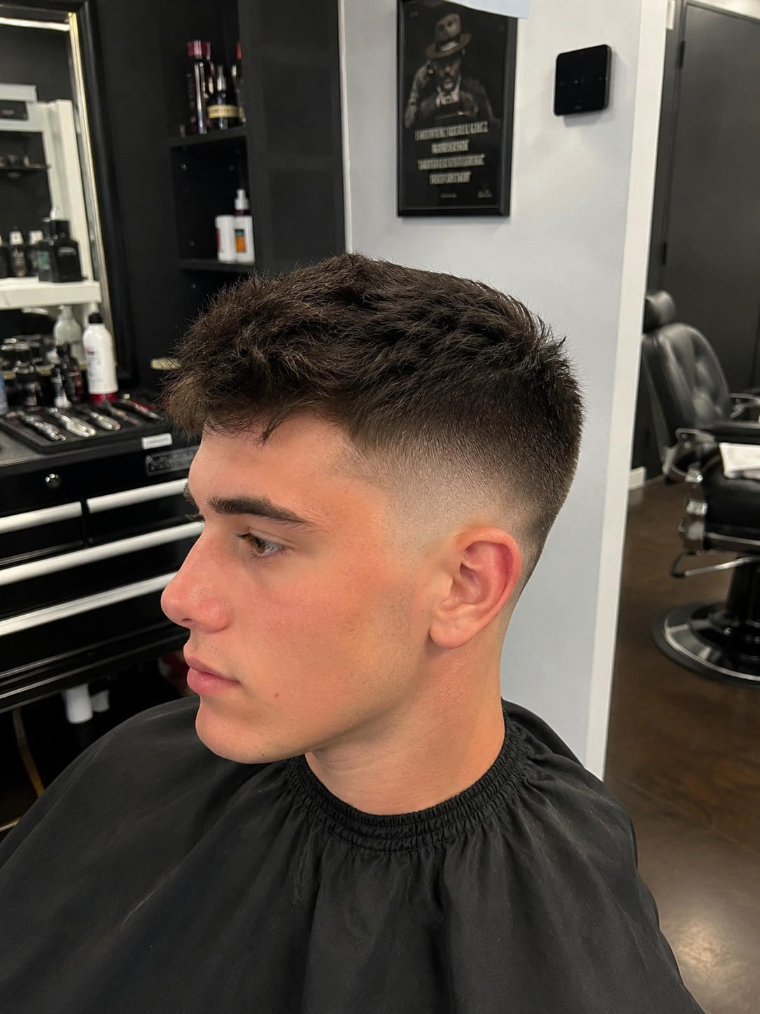 Young male client with a textured crop and skin fade haircut, showcasing a clean, modern men's hairstyle.
