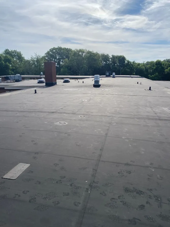 Wide view of a black EPDM rubber roof membrane on a commercial building