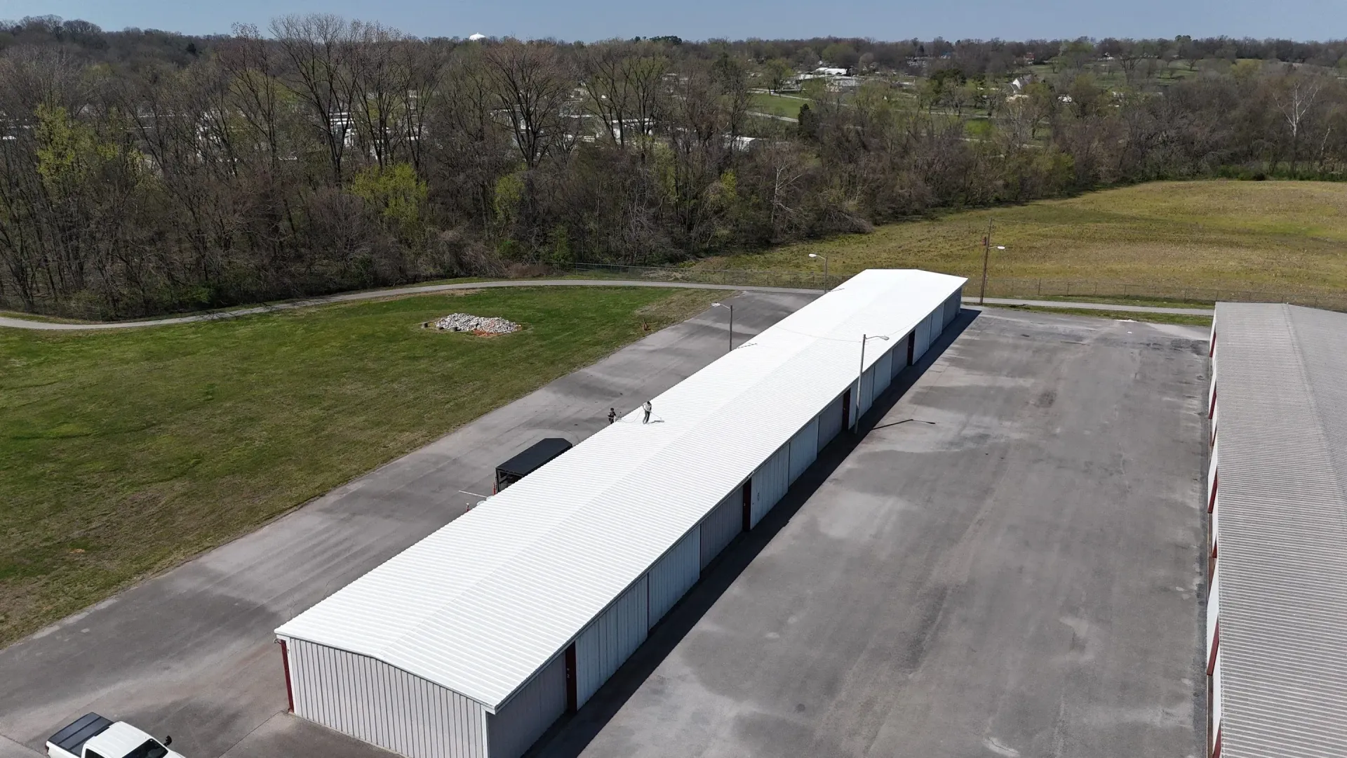 Aerial view of completed metal roof restoration with white reflective coating in Hopkinsville, Kentucky
